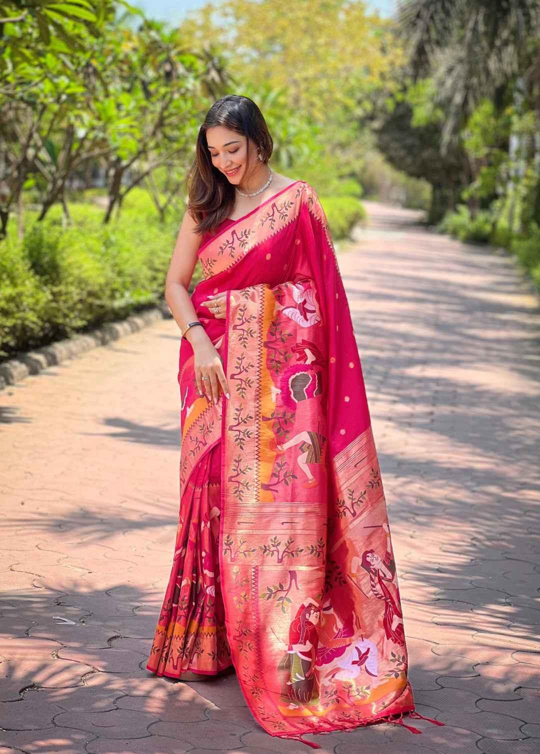 Woman wearing rani pink Paithani silk saree with traditional zari weaving and artistic motifs, standing outdoors