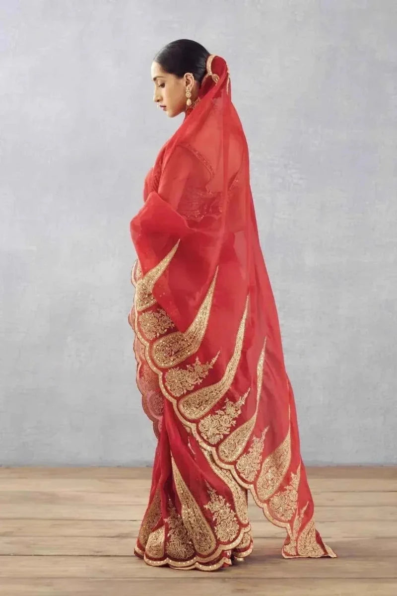 Red organza saree with gold scalloped pallu embroidery, shown from side