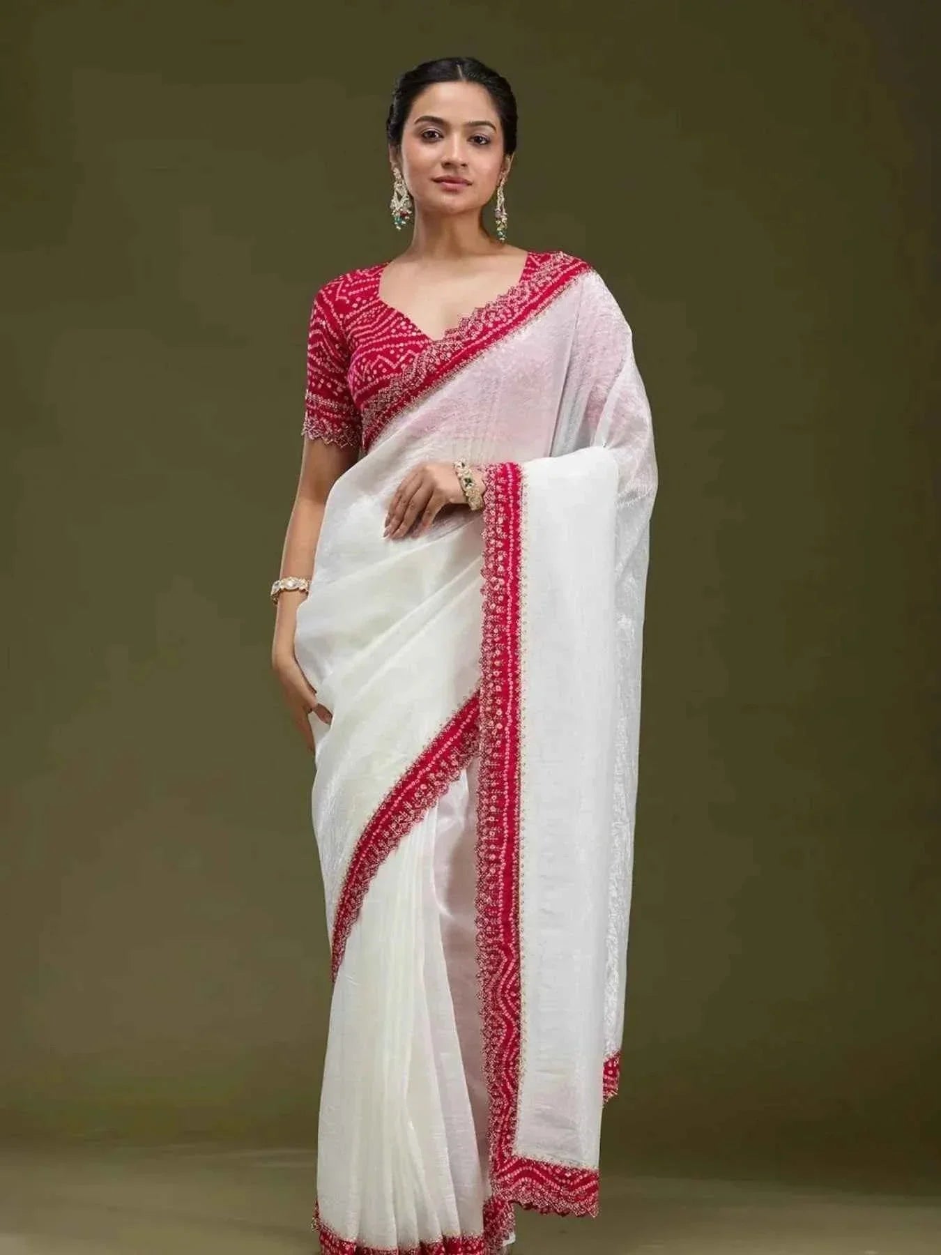 Woman wearing elegant white tissue saree with red Bandhani blouse and matching red border