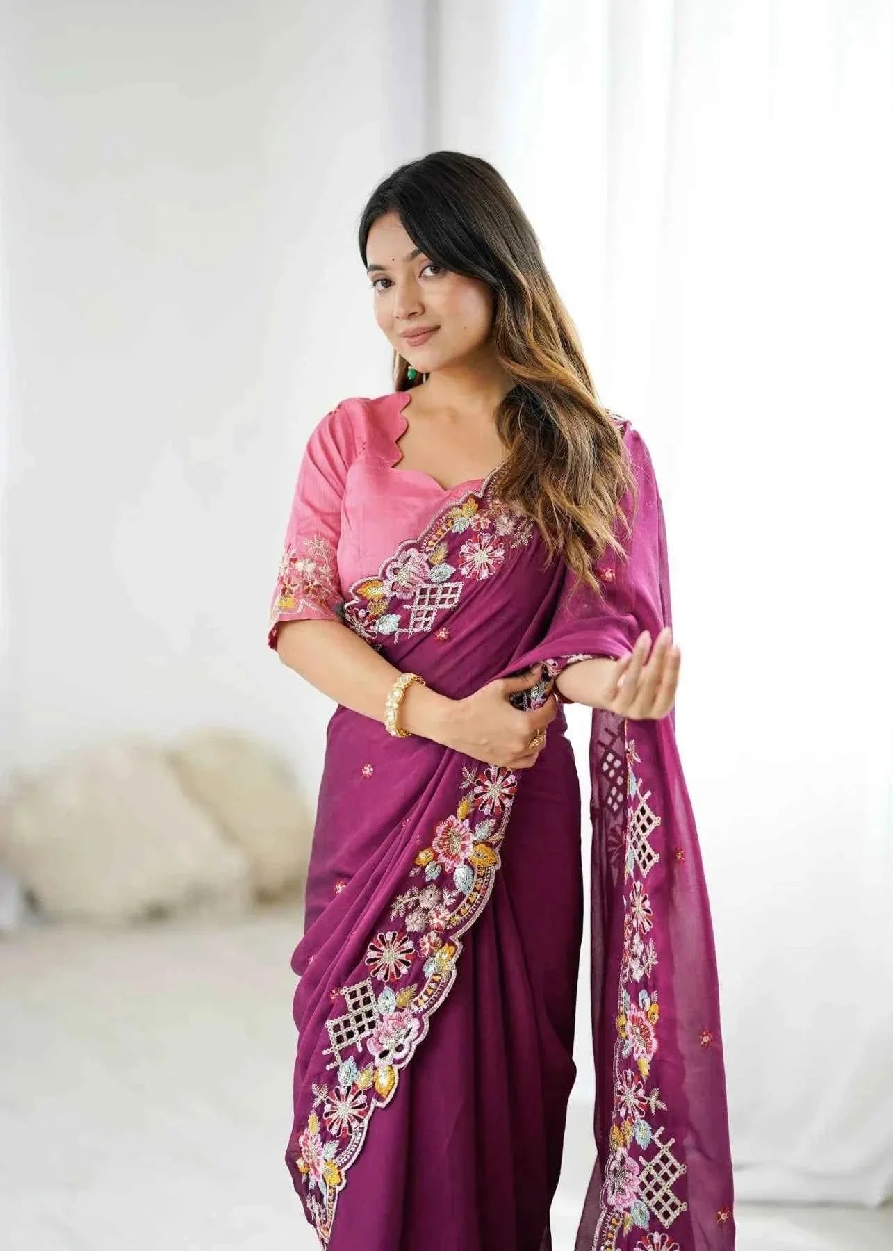 Woman wearing a wine crush saree with sequin cutwork and floral embroidery in a bright indoor setting