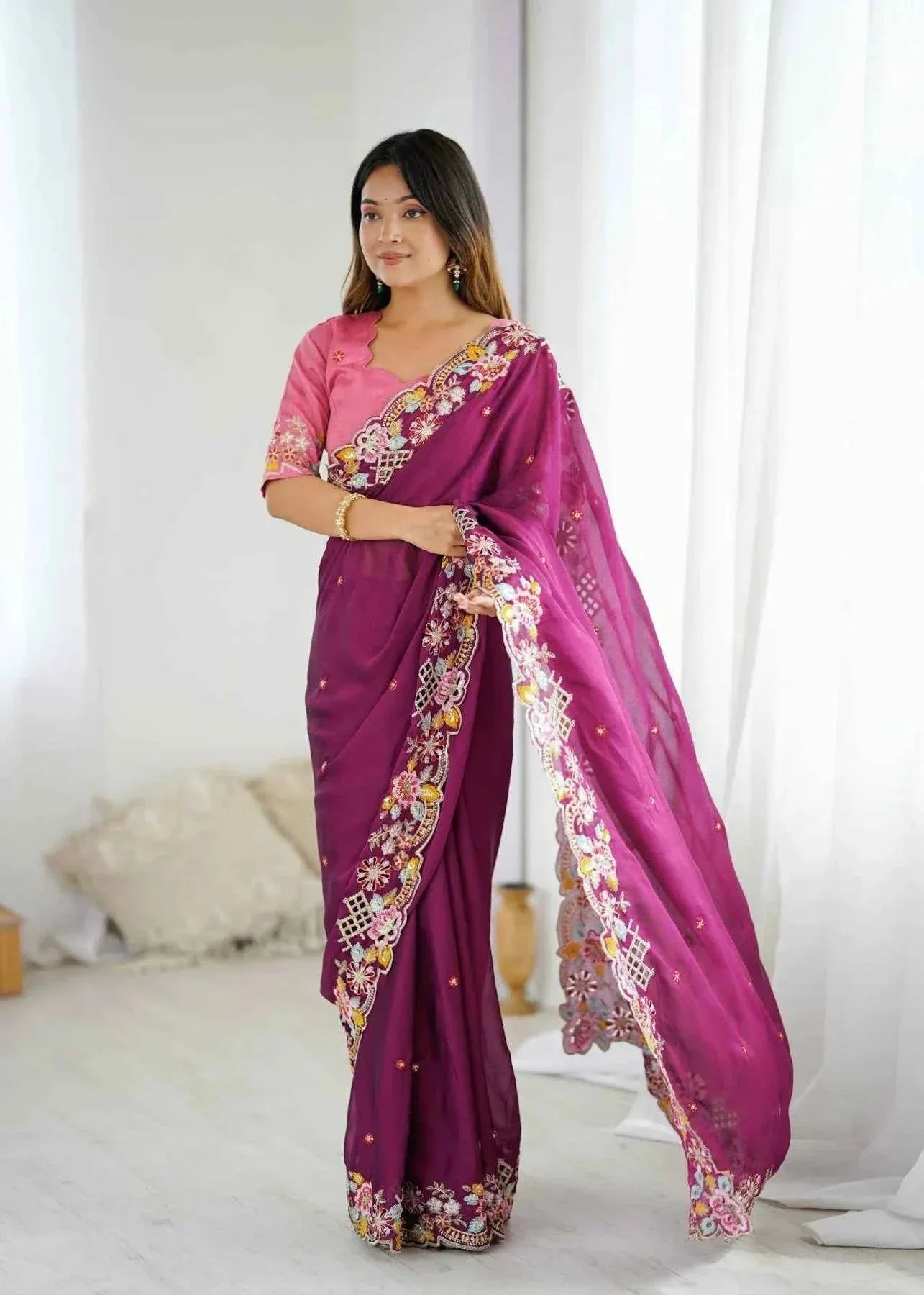 Woman wearing wine-colored saree with sequin cutwork embroidery and pink blouse in bright indoor setting