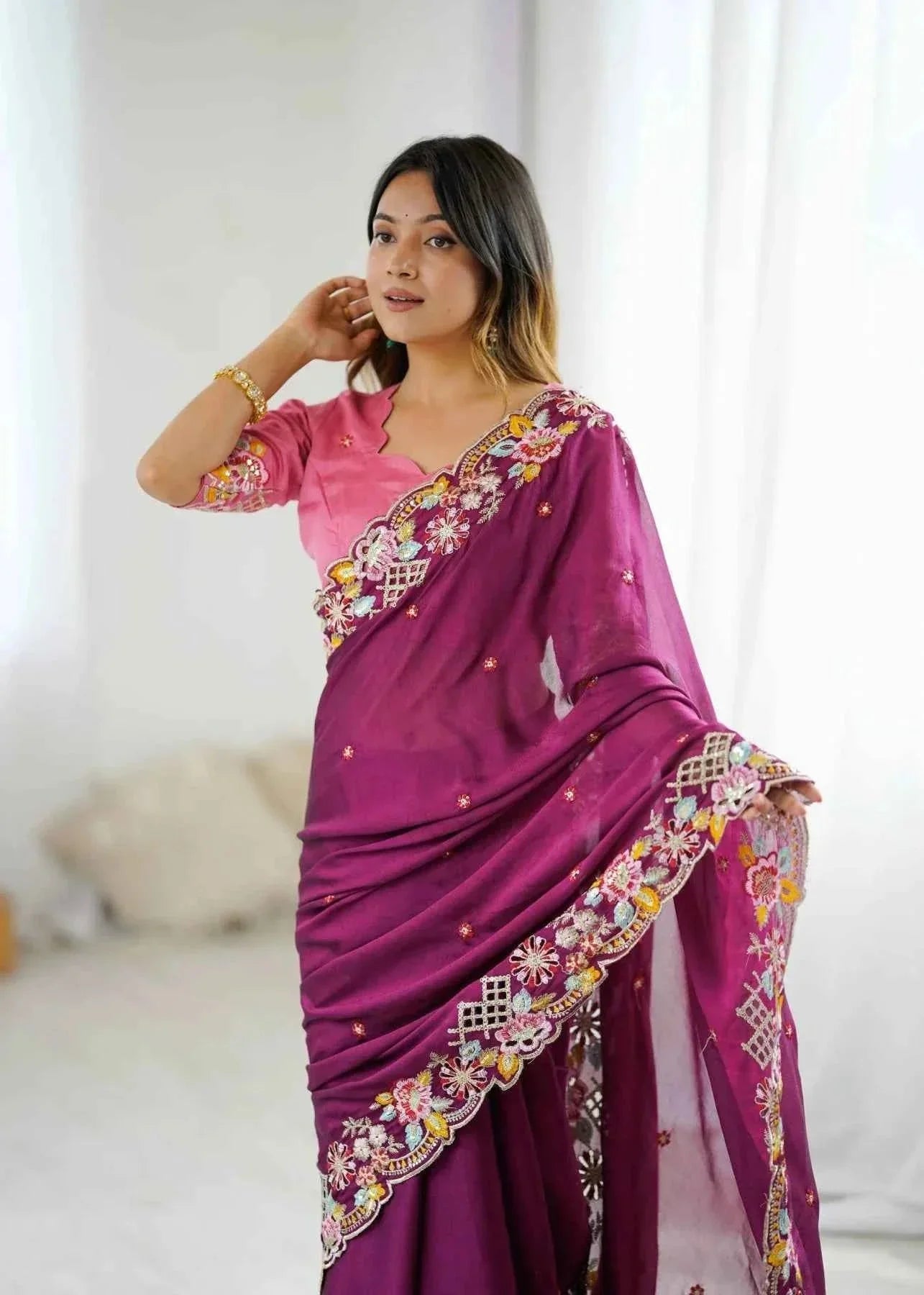 Woman wearing wine-colored saree with sequin cutwork embroidery and floral designs indoors